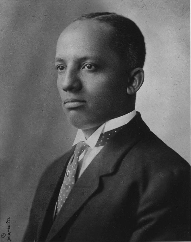 Old black and white photo portrait of black man in suite with tie.